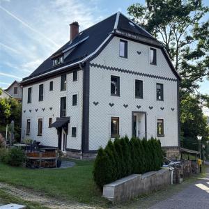 Elegantes zweistöckiges weißes Haus im rustikalen Stil in malerischer Dorflage.